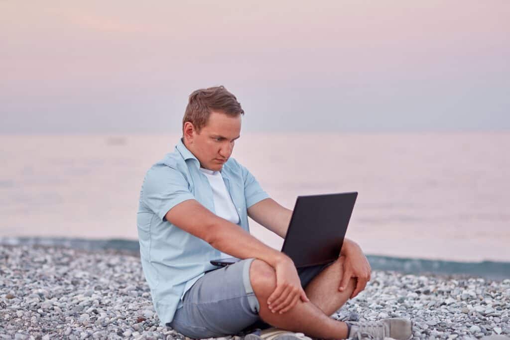man working with laptop on the beach near the sea 2022 05 19 07 17 02 utc