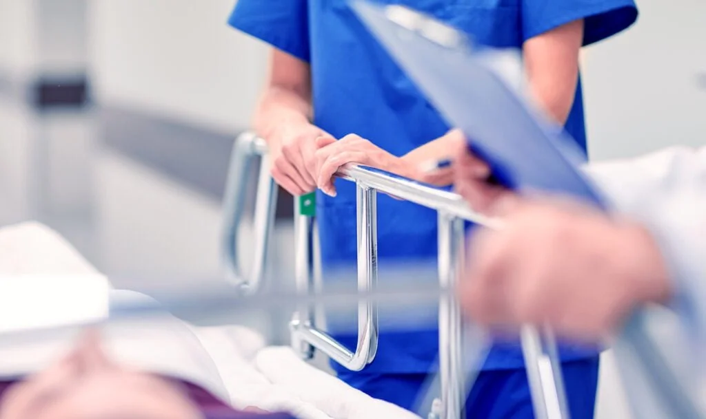 Prevalence of Workplace Injuries for Healthcare Professionals: How Workers’ Comp Can Help 3 medics and patient on hospital gurney at emergency 2022 12 16 09 46 42 utc