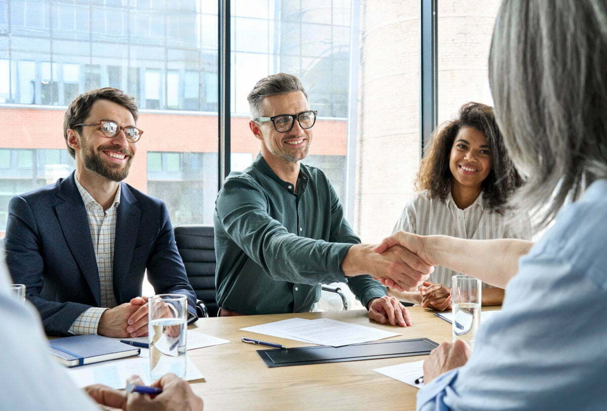 Happy businessman and businesswoman shaking hands